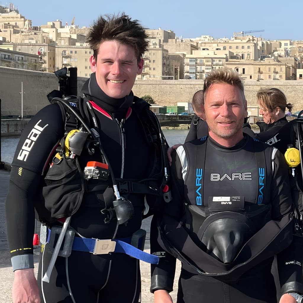 Shaun in scuba gear with a dive buddy